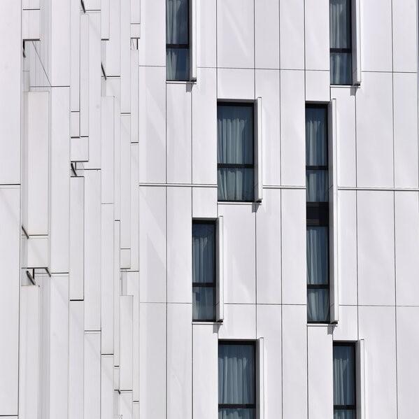 Revêtement de façade en panneaux composites Habillage de façade avec des panneaux blancs et des vitres.